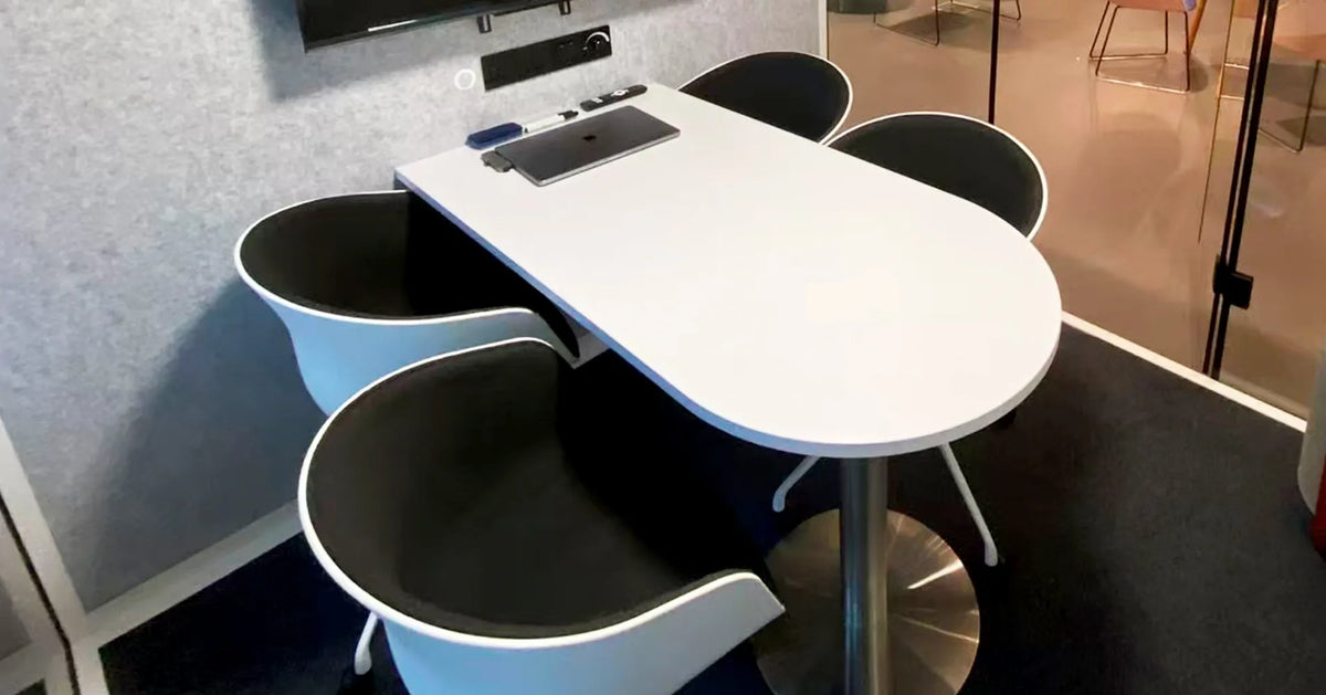 Interior view of 4 seater acoustic meeting pod, compact meeting table and chairs inside soundproof office booth